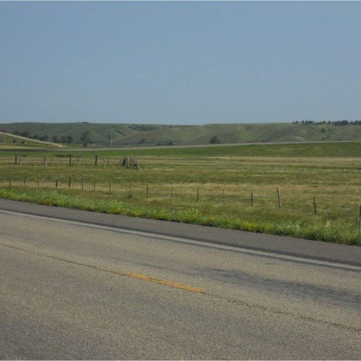 Taken beside the two-lane highway, this photo shows the valley with the hills rising in the distance. 