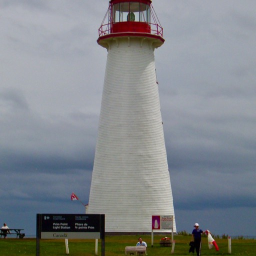 Photo of the Prim Point lighthouse with the cloud-covered sky in the background. 