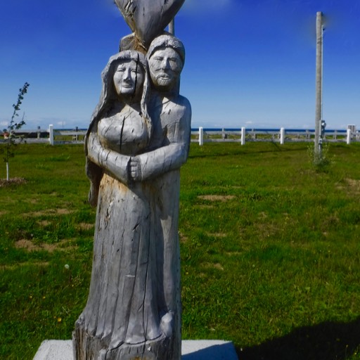 Sculpture of a mang standing behind a woman. His arms are around her from behind. They appear very much in love. 