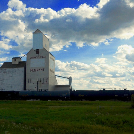 The old wooden grain elevator in Pennant, Saskatchewan, with tanker cars in front. 